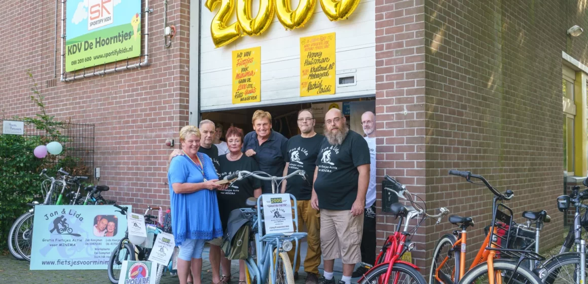 Henny Huisman reikt namens Fietsjes Actie voor Minima in Hoorn 2000e fiets uit